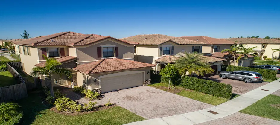 A large house with brown roof and tan garage.