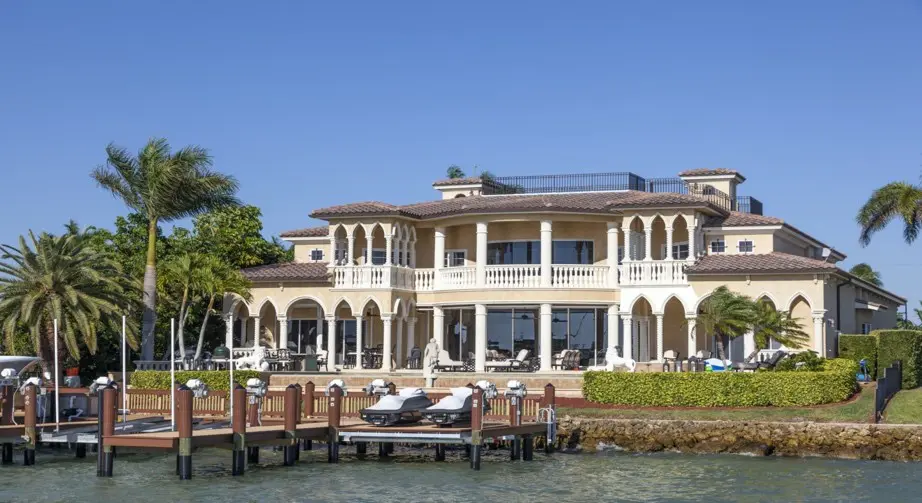 A large white house sitting on the water.