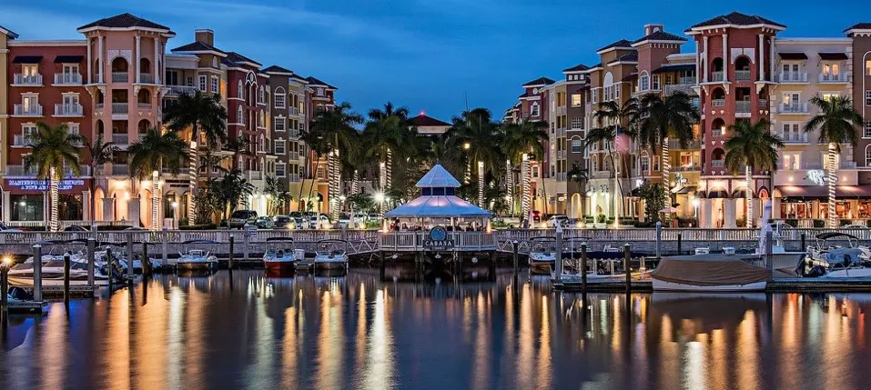 A marina with boats and buildings in the background.