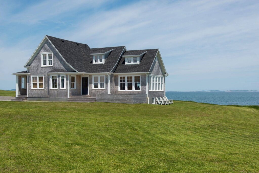 A house with grass and water in the background.