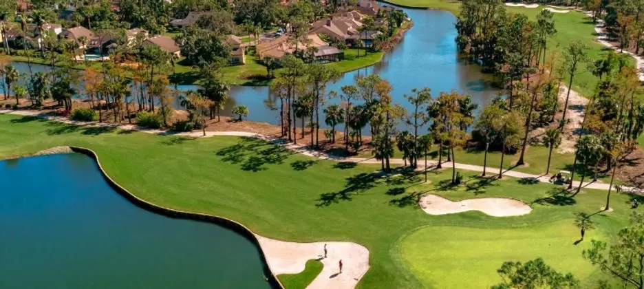 A golf course with many trees and water