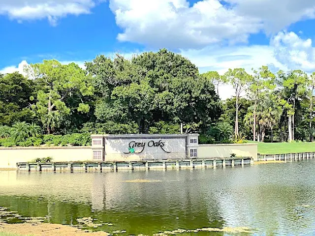 A sign that says deep creek in front of the water.