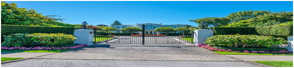 A gated driveway with trees in front of it.