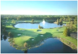 A golf course with water and trees in the background.