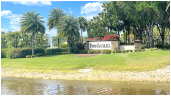 A large sign that says two eagles in front of some trees.