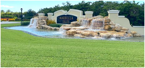 A sign that says marella isles with water fall in the background.