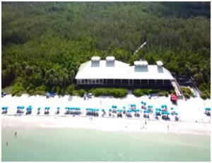 A beach with many chairs and umbrellas on the sand.