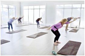 A group of people doing yoga in a gym.