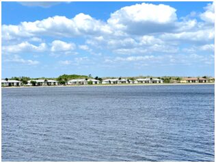 A view of houses on the water from across the lake.