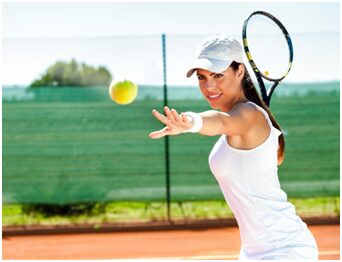 A woman swinging at a tennis ball with her racket.