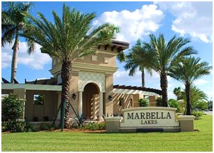 A sign that says marbella lakes in front of some palm trees.