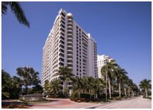 A large white building with palm trees in front of it.