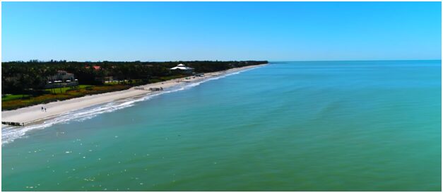 A beach with green water and blue sky