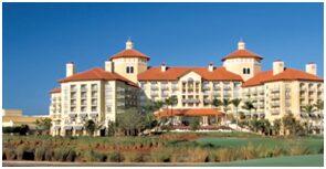 A large hotel with a golf course in the foreground.