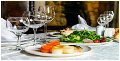 A plate of food and wine glasses on the table.